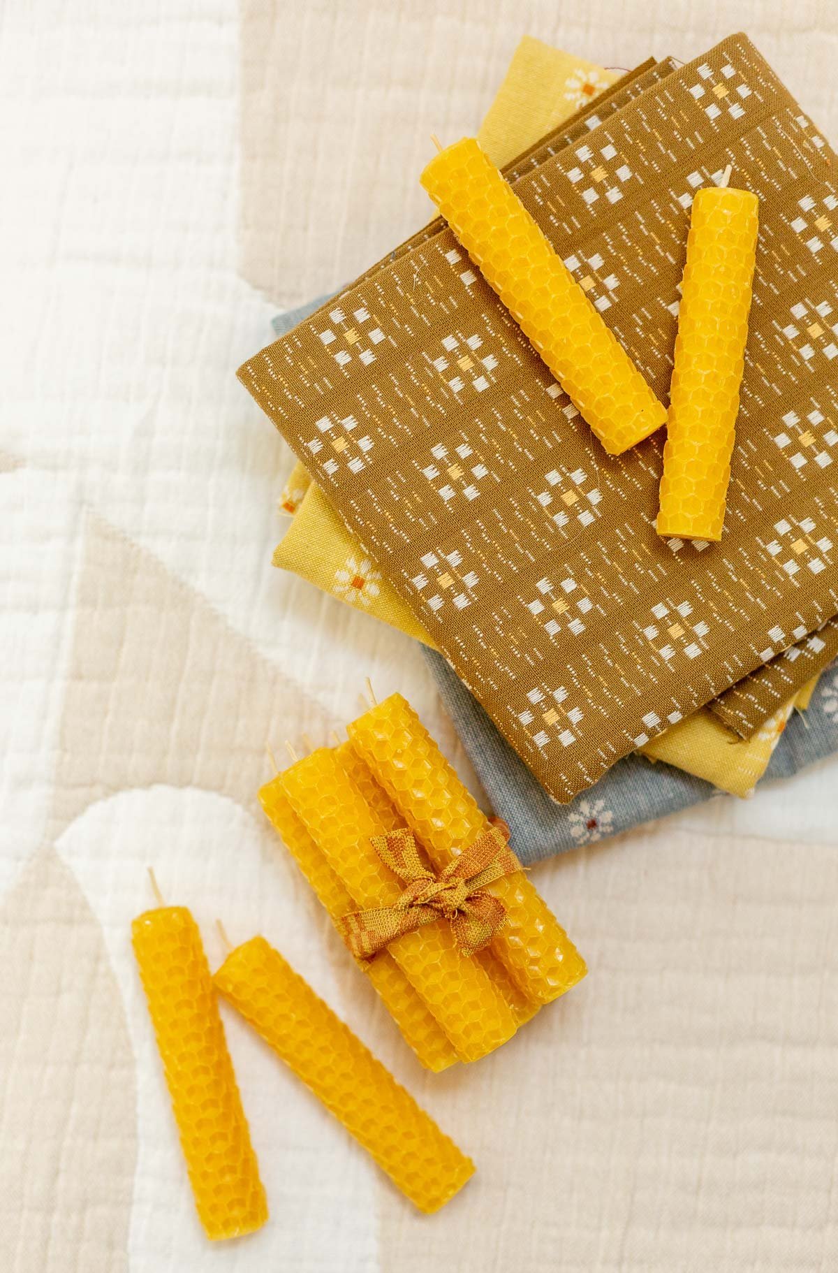 homemade beeswax candles in small sets on a geometric background with neutral colors