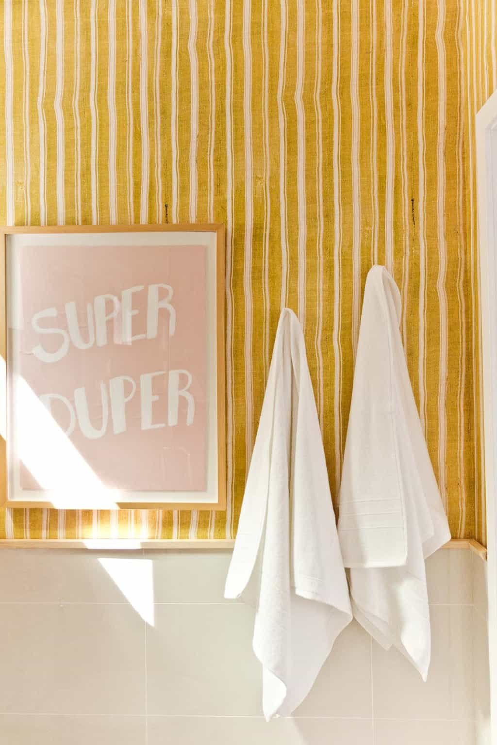 striped yellow wallpaper in cheerful, minimal bathroom space