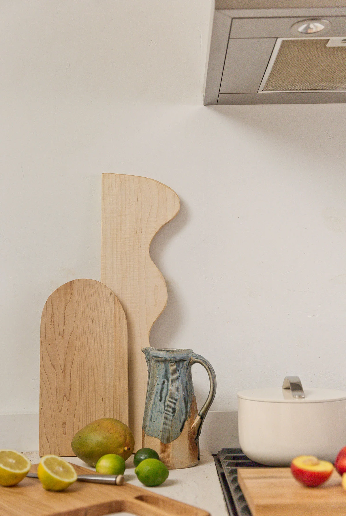 wood cutting boards on a minimal neutral countertop kitchen with citrus