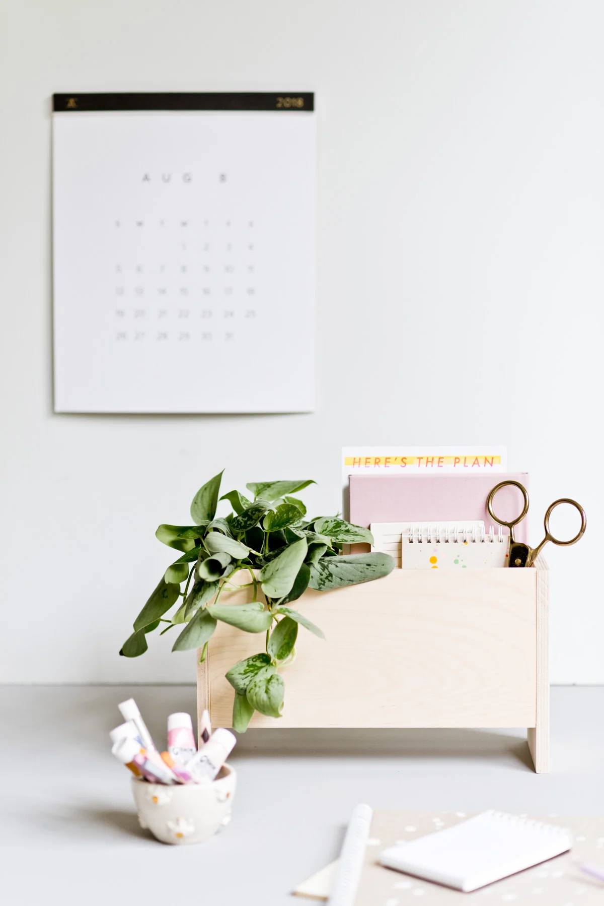 wood desk organizer with minimal modern design and plant and notebooks inside