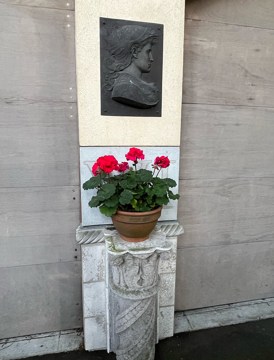 red geranium on ornamental pillar