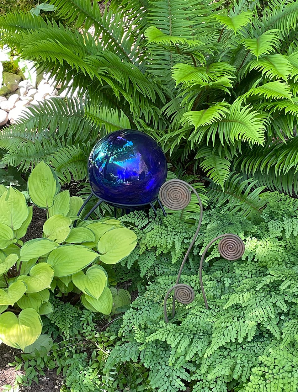 blue garden orb surrounded by bright green foliage