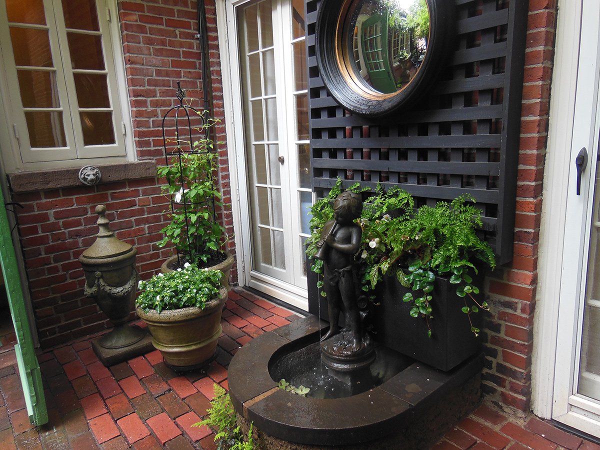 container plantings next to a small garden fountain 