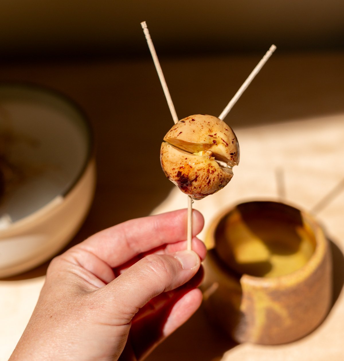 avocado pit split open with three toothpicks stuck in it