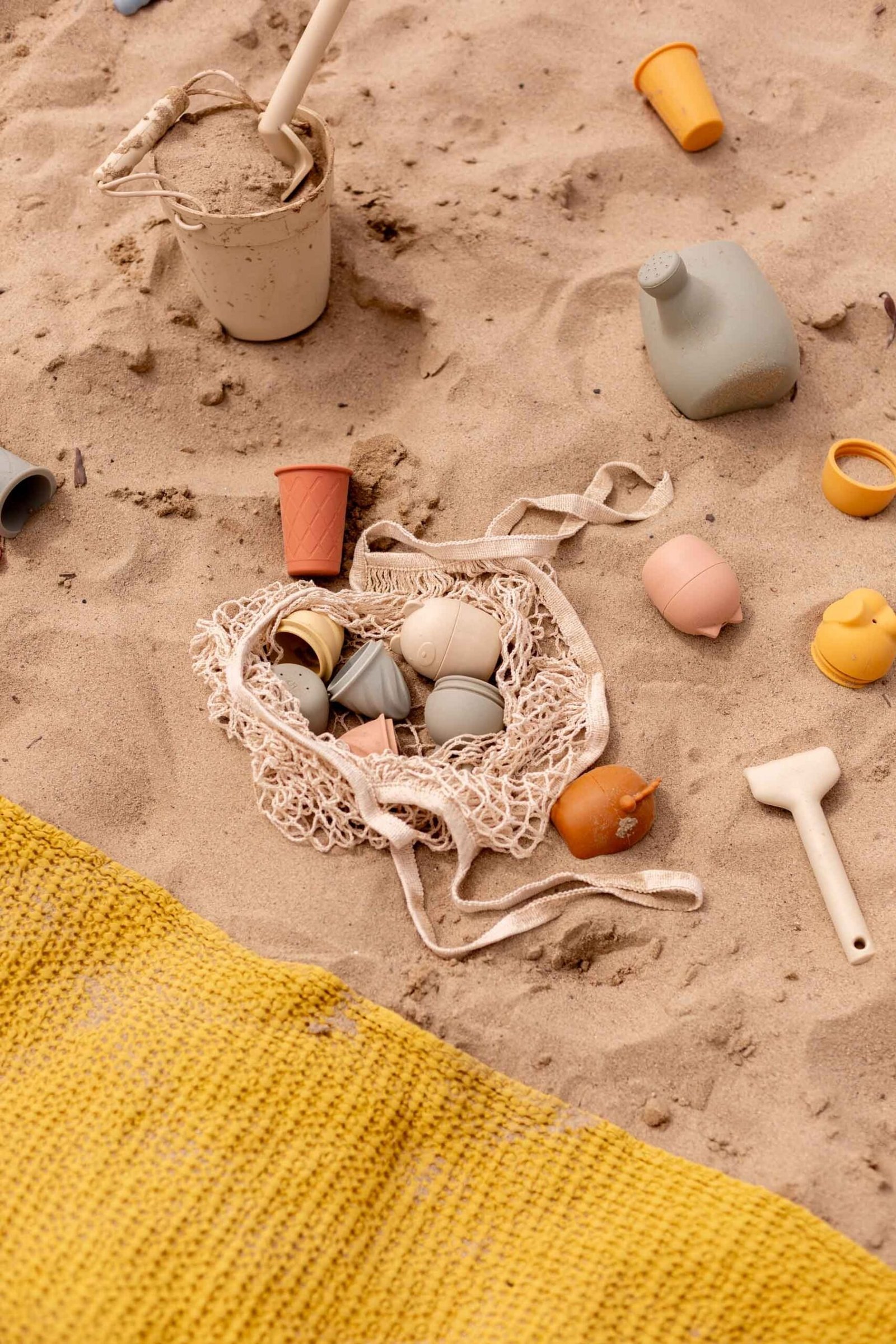 kids sand toys at the beach with colorful towel