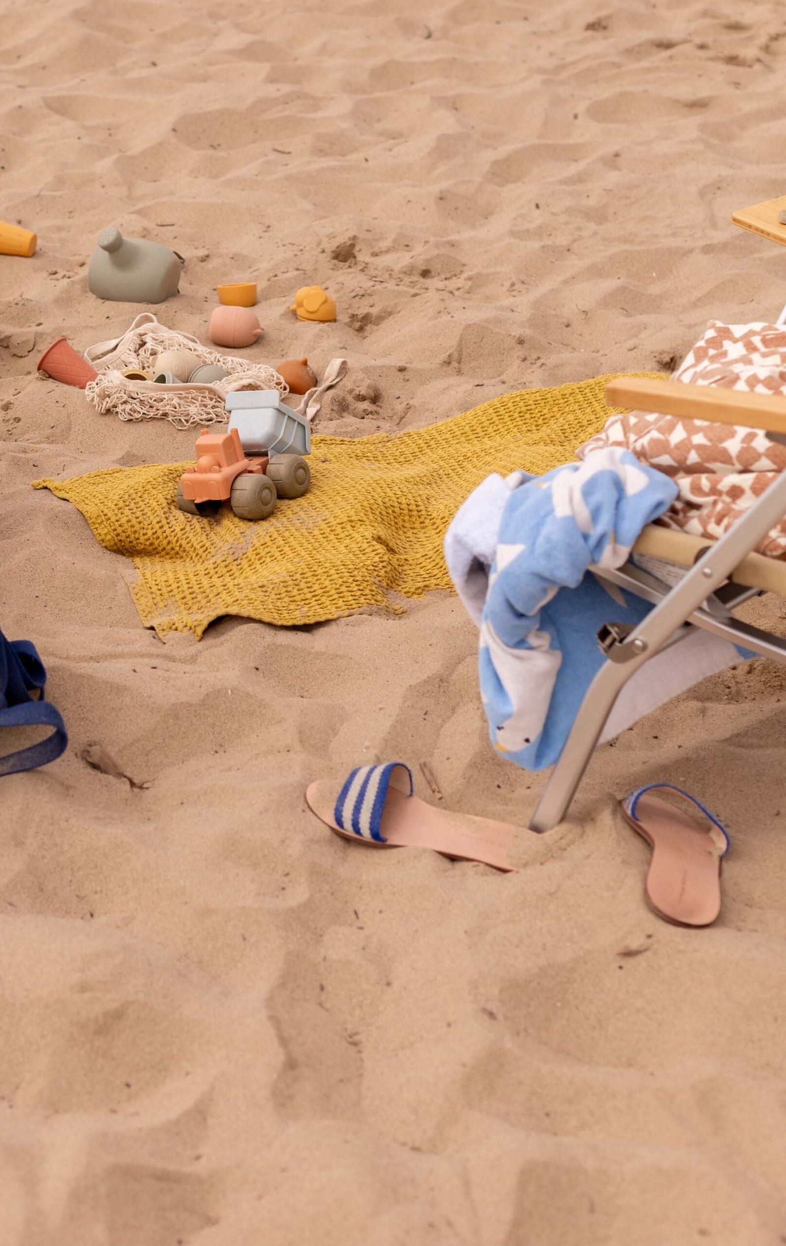 beach setup with women's sandals and kids neutral beach toys